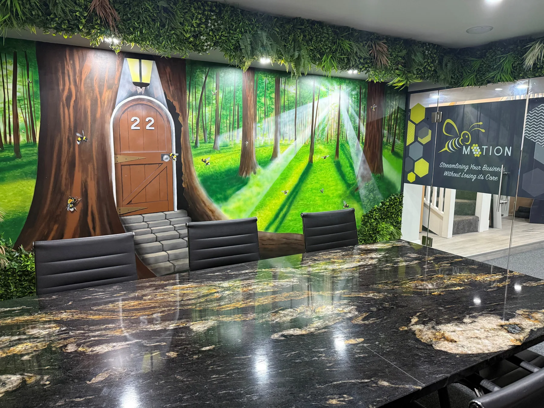 The Bee Motion meeting room in Stockport, with a forest mural and marble meeting table